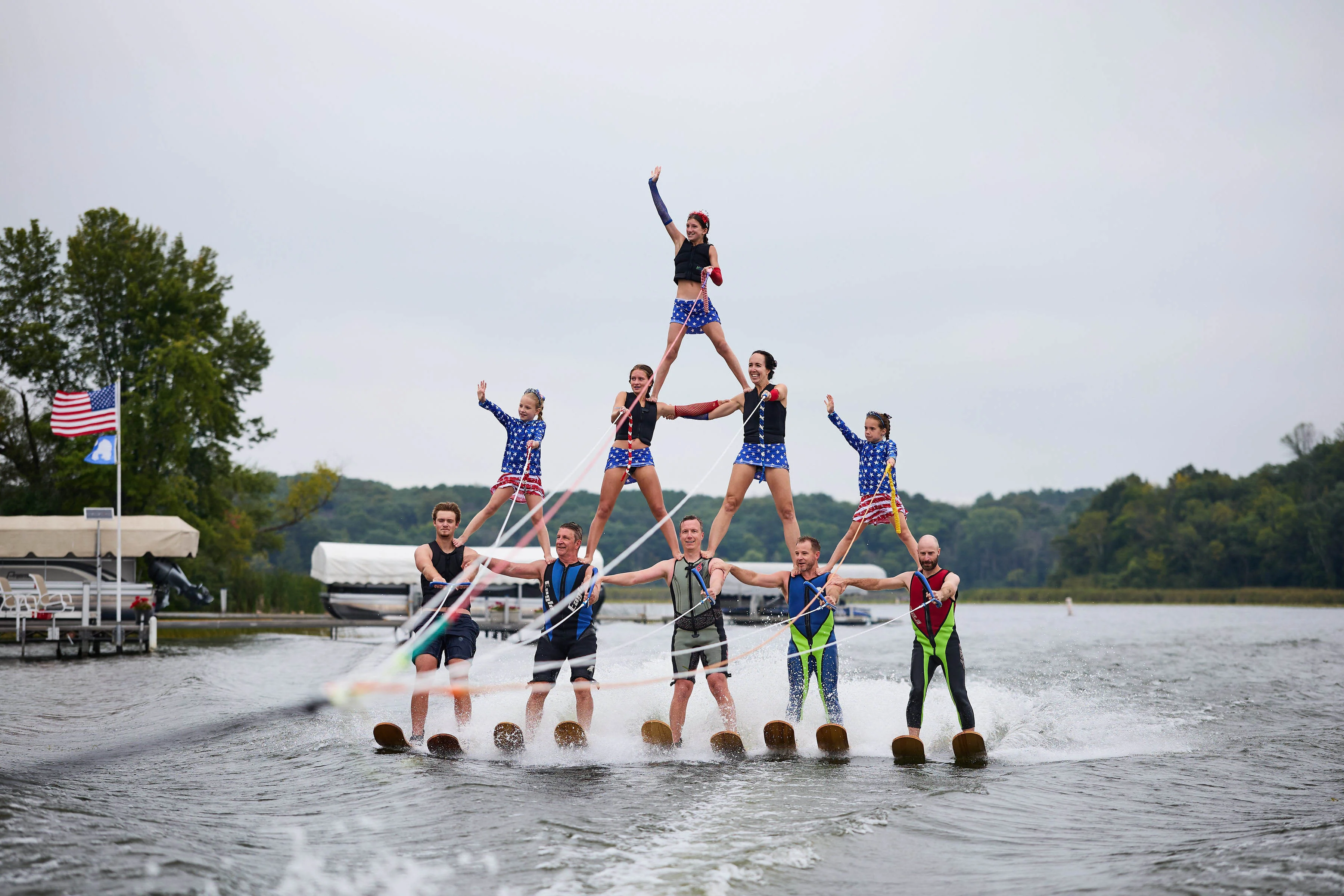 Lake Minnewashta Water Ski Club waterski pyramid with boat and American flag on the lake