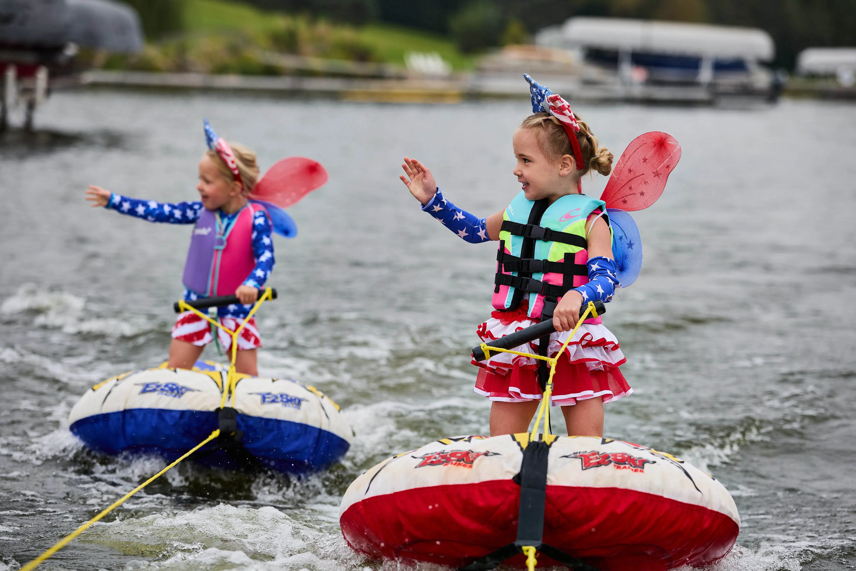 Young girls learning to waterski with patriotic fairy wings