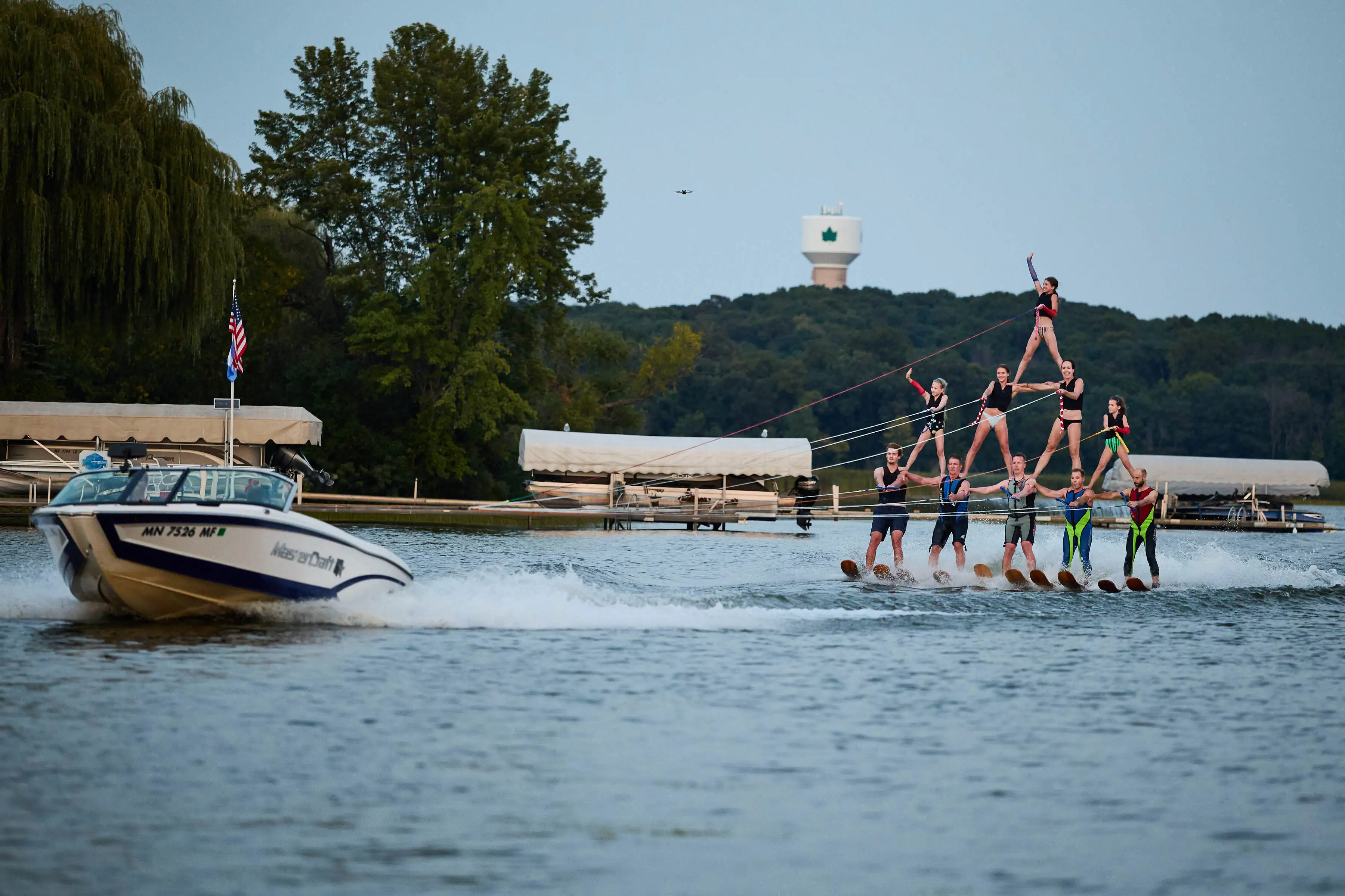 Waterski pyramid with boat and American flag on Lake Minnewashta